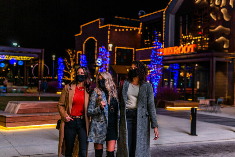 Three women wearing masks and walking around outside while shopping at Easton Town Center.