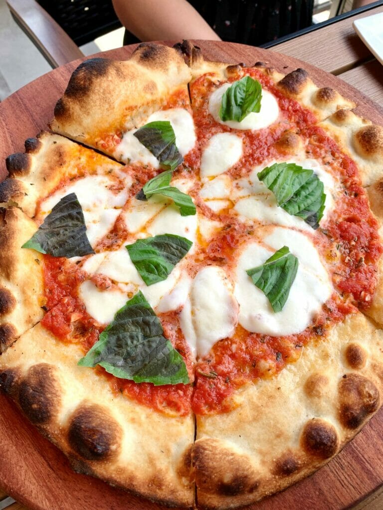 A cheese pizza with basil leaf garnishes at Sono Wood Fired, an Italian cuisine restaurant at Easton.