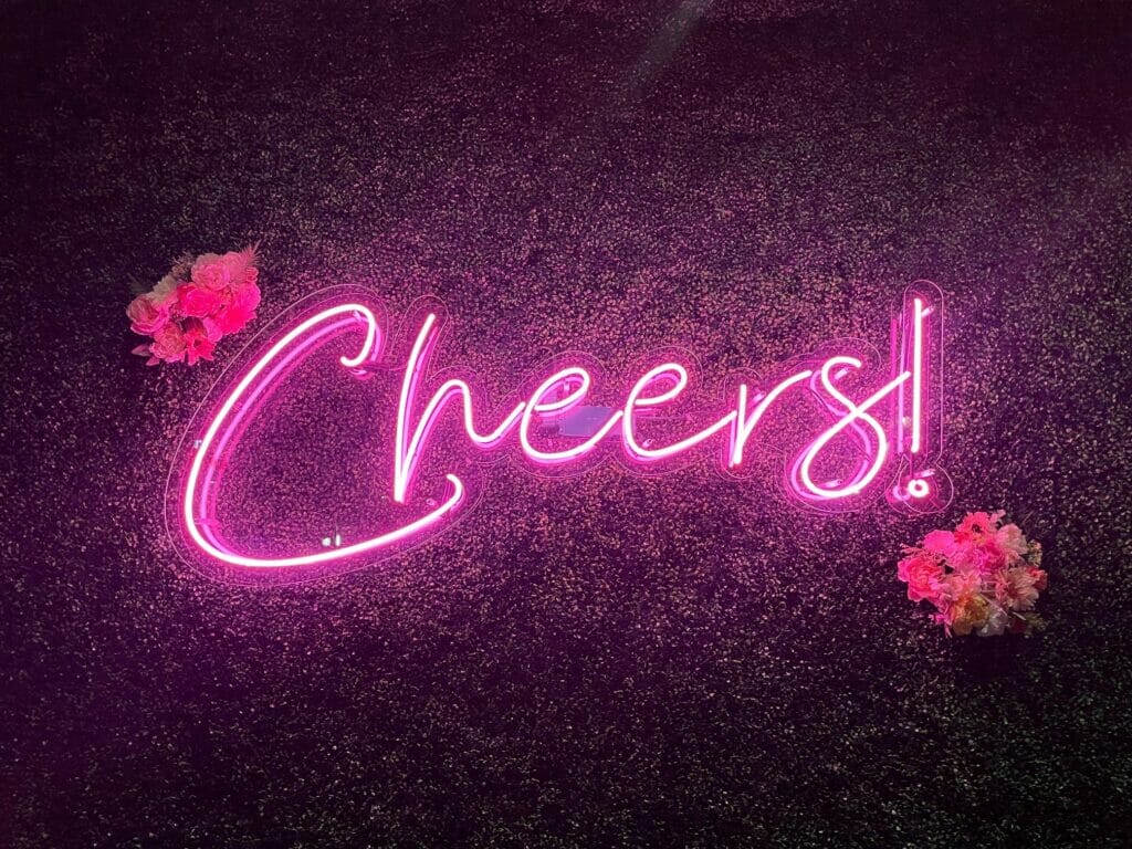 The lit up pink Cheers sign at Prosecco Plaza.