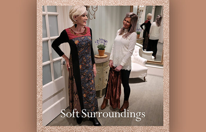 Two women standing in a Soft Surroundings store trying on clothing.