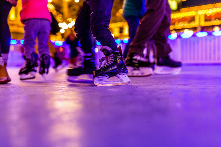Close up of people's feet in ice skates skating on the rink at Easton during the holiday season.