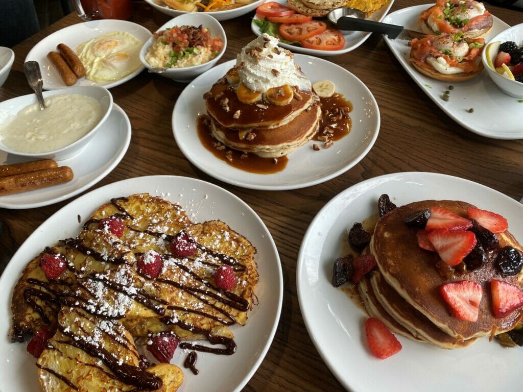 Multiple meals on plates laid out on a table at Another Broken Egg at Easton Town Center.
