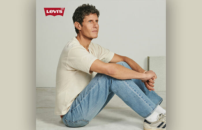 A man sitting down and wearing Levi's clothing.