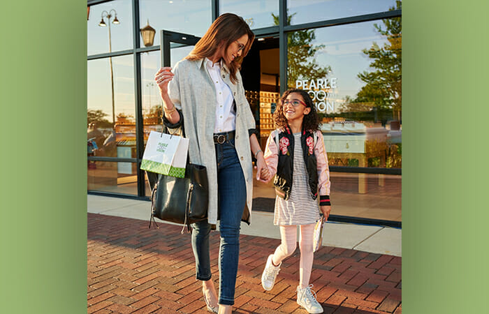 A woman and her daughter holding hands and leaving a Pearle Vision location.