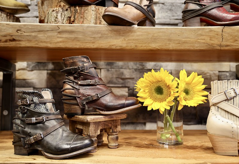 Booties displayed on wooden table with sunflowers
