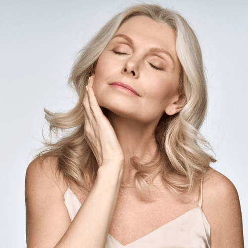 A woman admiring her softer, well-treated skin.