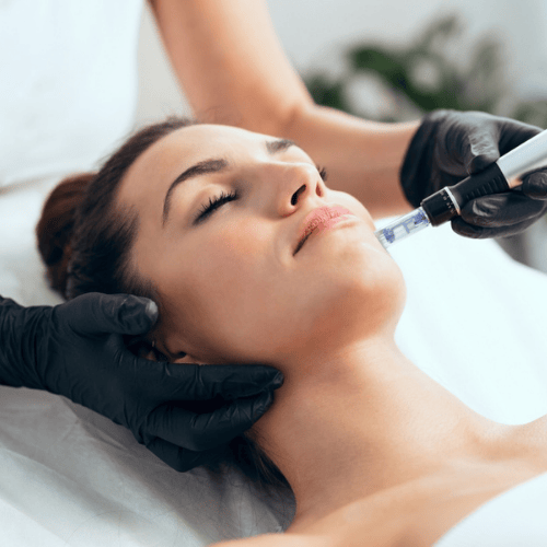 A woman laying on a spa table getting a facial treatment.
