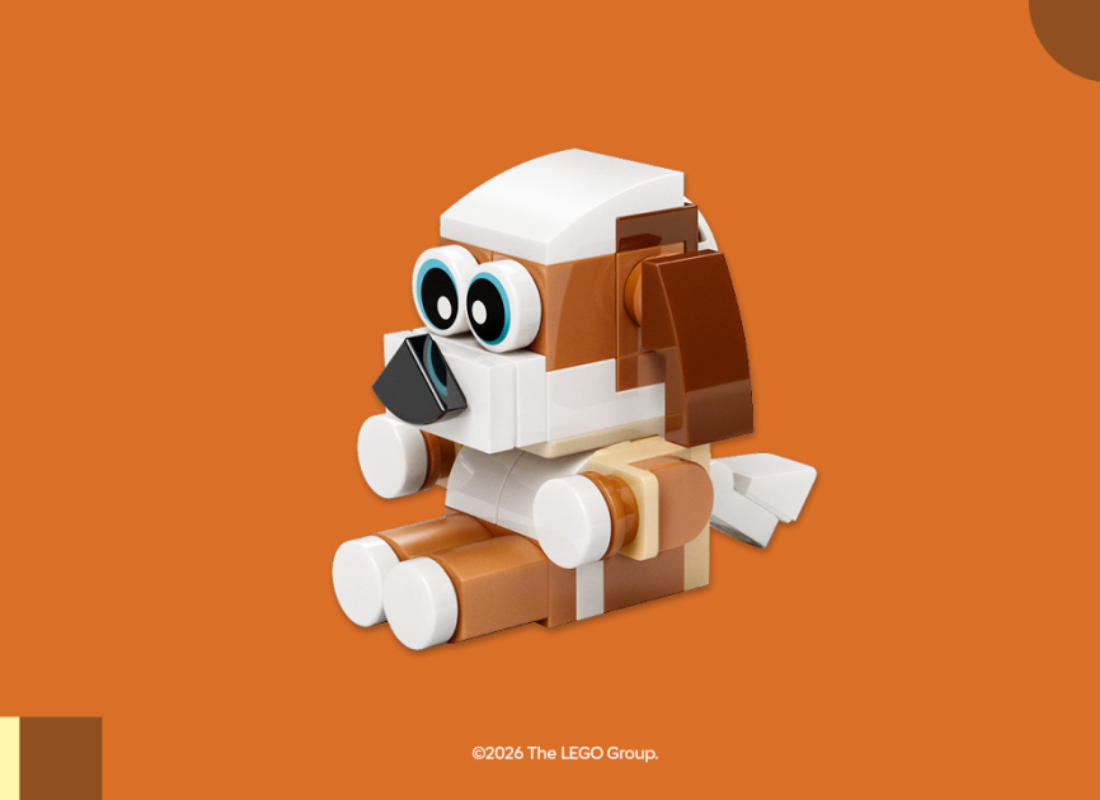 White and brown dog made out of Lego pieces sitting and looking to the left.
