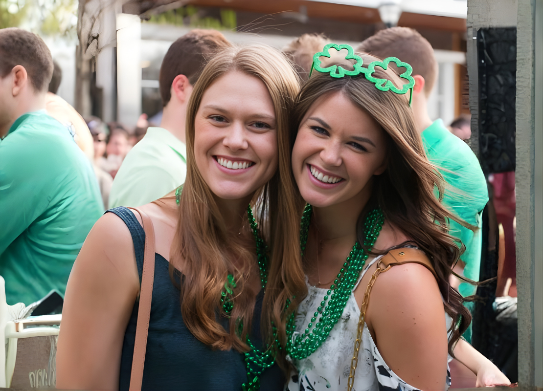 Two women smiling wearing St. Pattys day green