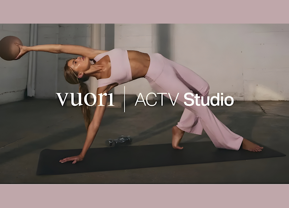 Women doing yoga holding a medicine ball wearing a pink workout set on a yoga mat