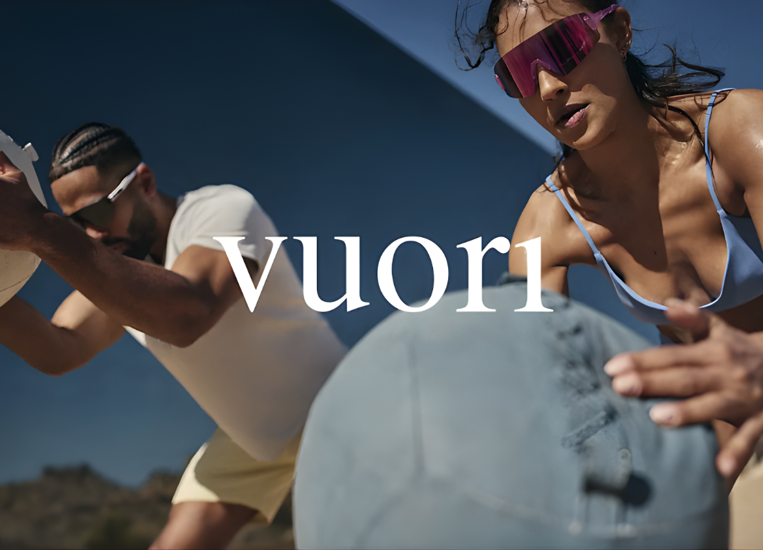 A woman and man participating in an outdoor workout with Vuori brand logo