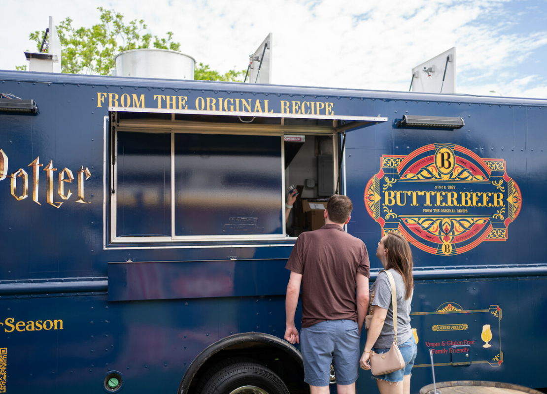 A couple ordering a butterbeer slushie from the butterbear truck